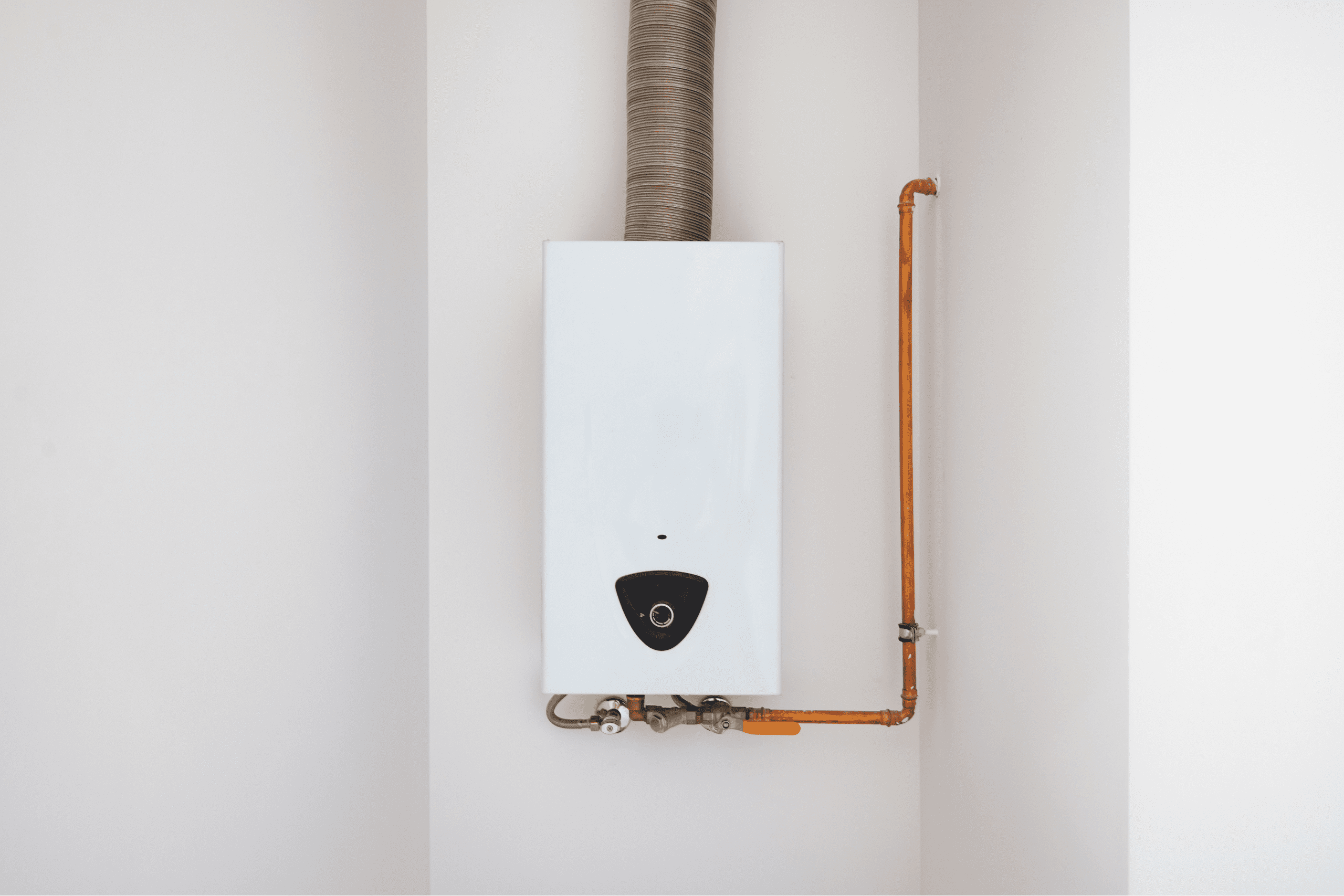 Chauffe eau blanc installé dans le coin d'un mur d'une salle de bain rénovée